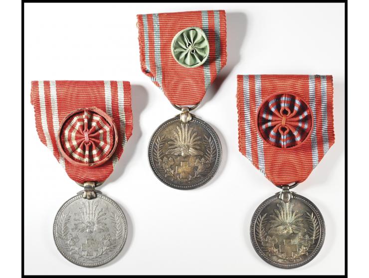 each featuring the rising sun and red cross emblem on obverse and inscribed reverse. Mounted with red and white ribbons, two 